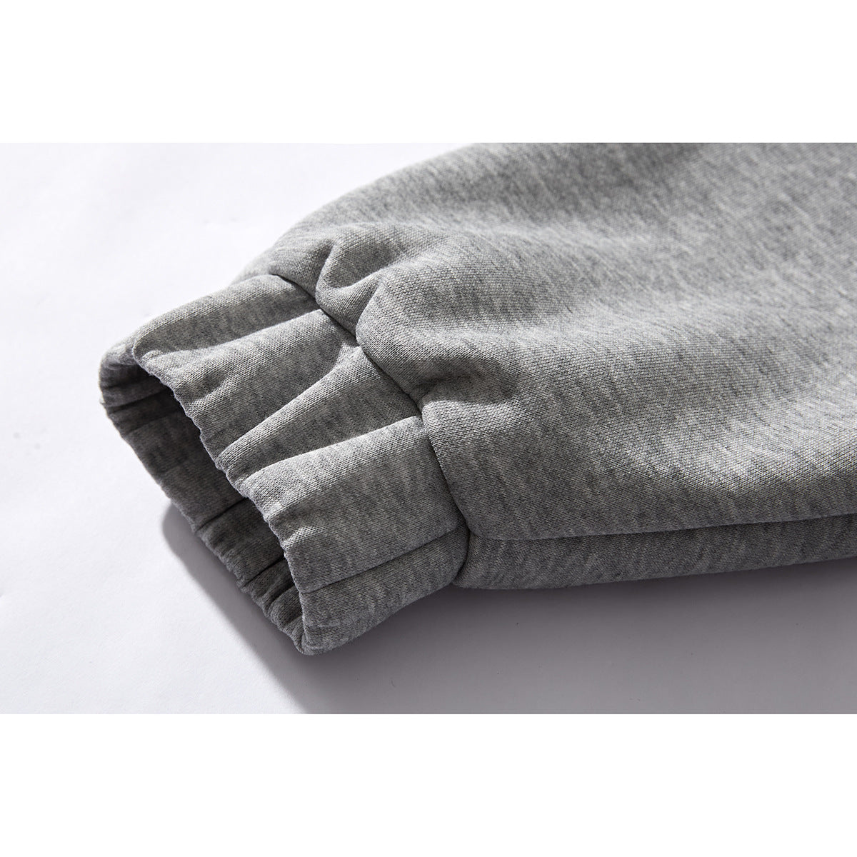 Close-up of the gathered ribbed cuff on a gray jacket sleeve.