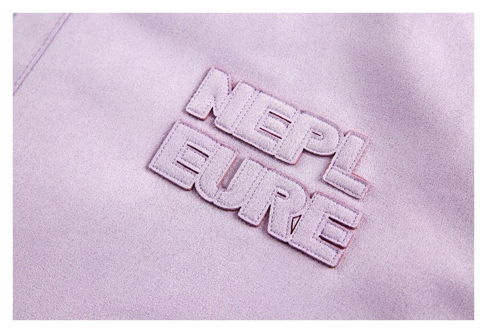 Close-up of raised lilac NEPLEURE lettering embroidered on the jacket.