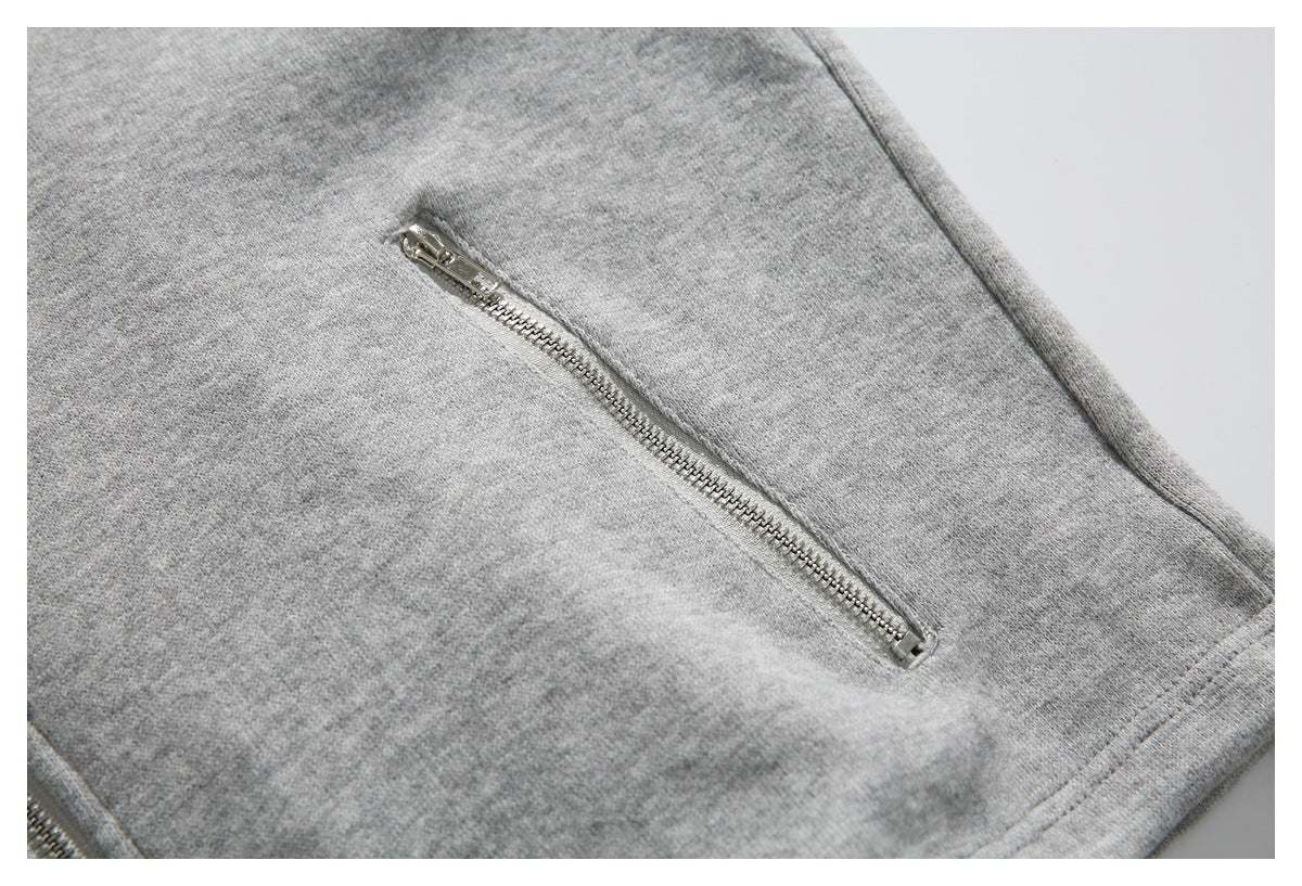 Close-up of a slanted silver zipper pocket on heather gray knit fabric.