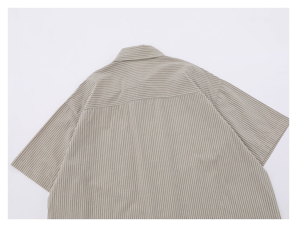 Back view of a beige short-sleeve button-up shirt with narrow vertical stripes and a horizontal yoke.