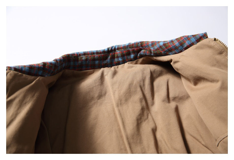 Close-up of the jacket opened to show its plain tan lining and plaid inner edge.