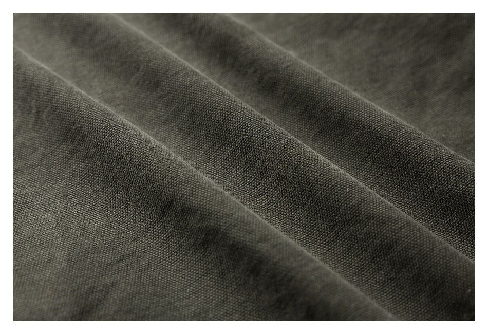 Close-up of dark gray woven fabric arranged in soft folds.