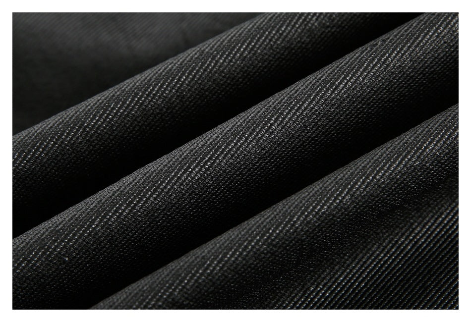 Macro view of textured black garment fabric arranged in soft folds.