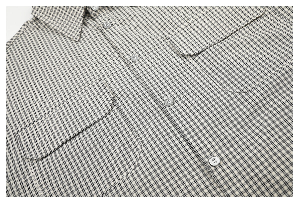 Close-up of a light checked shirt showing its front buttons and chest pockets.