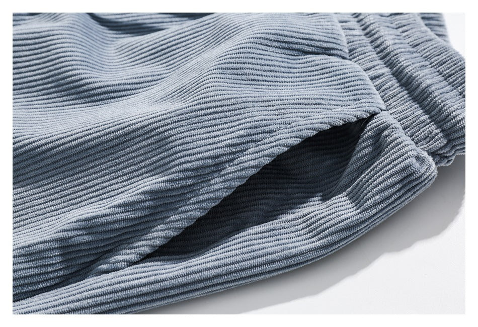 Close-up of a side pocket opening on light blue ribbed pants.