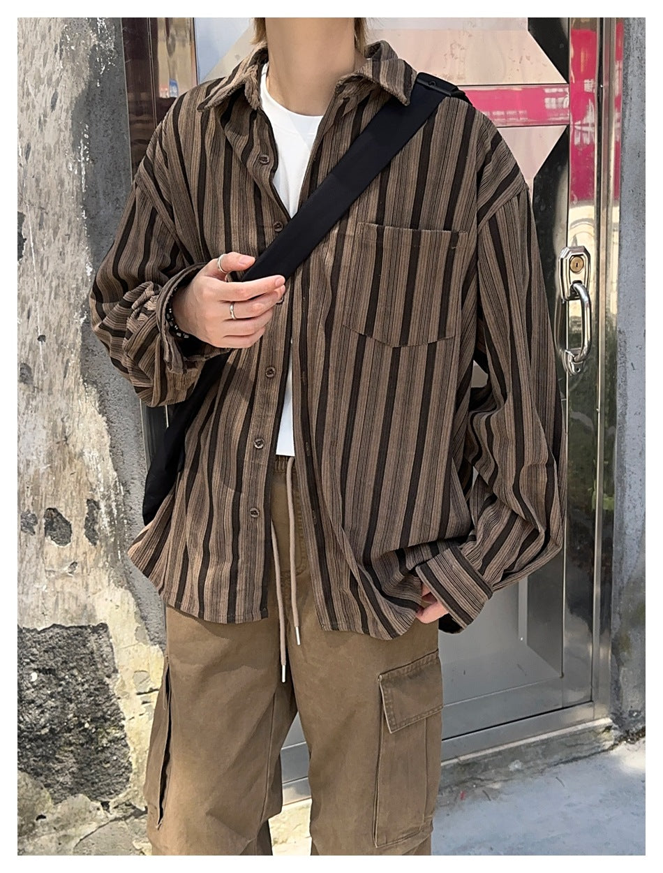 Close-up of the striped brown shirt worn open over a white tee with a black crossbody strap and cargo pants