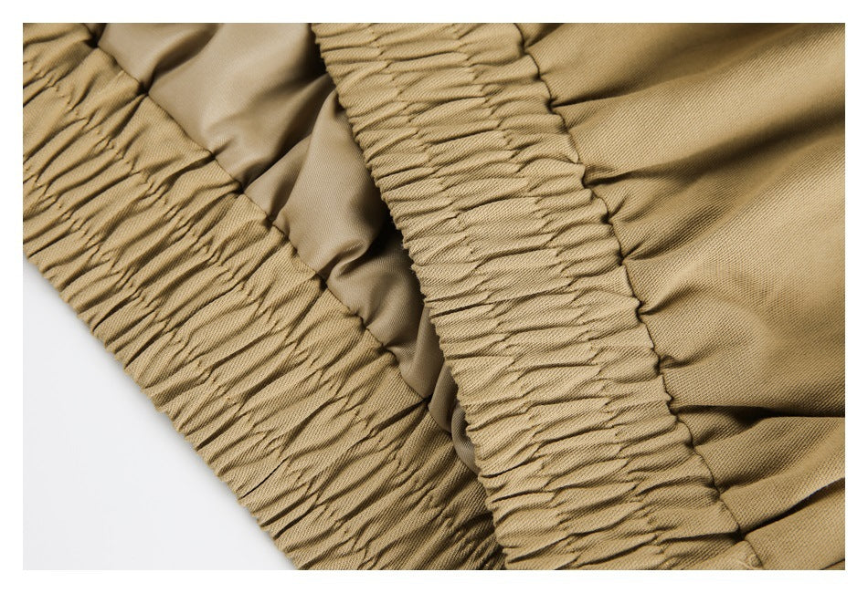 Close-up of gathered elastic sections and seams on a tan garment.