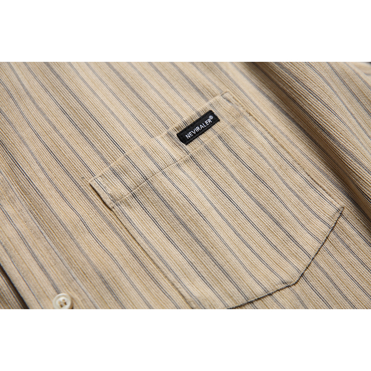 Close-up of a beige striped shirt's buttoned chest pocket and small sewn label.