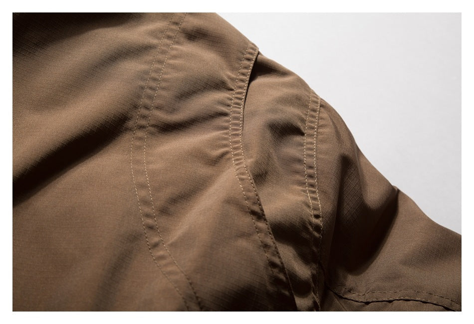 Close-up of curved stitched seams on a brown jacket shoulder and sleeve.