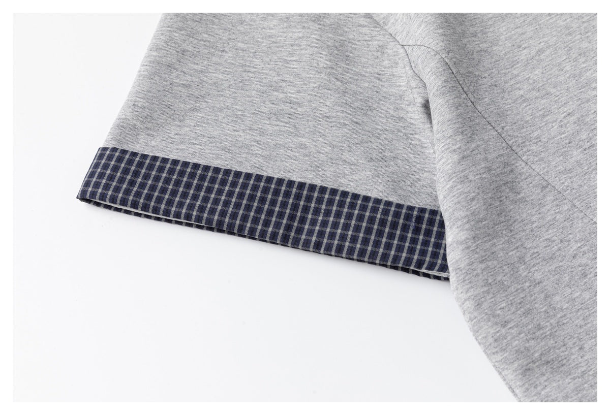Close-up of a gray T-shirt sleeve with a dark check-pattern cuff trim.