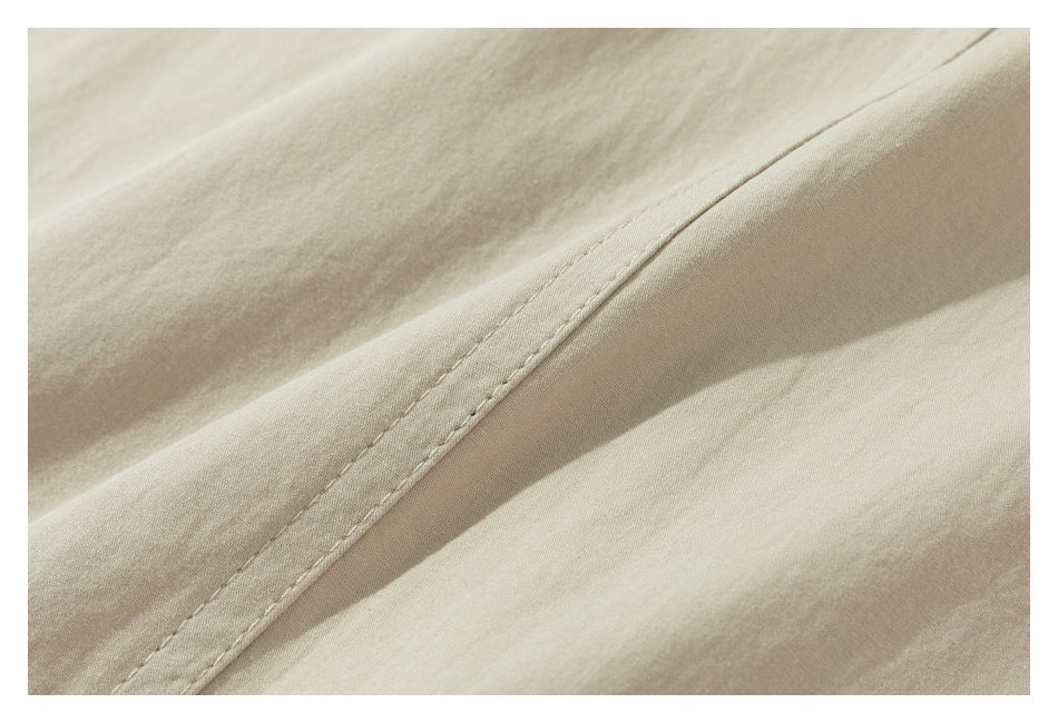 Close-up of a stitched seam on smooth beige garment fabric.