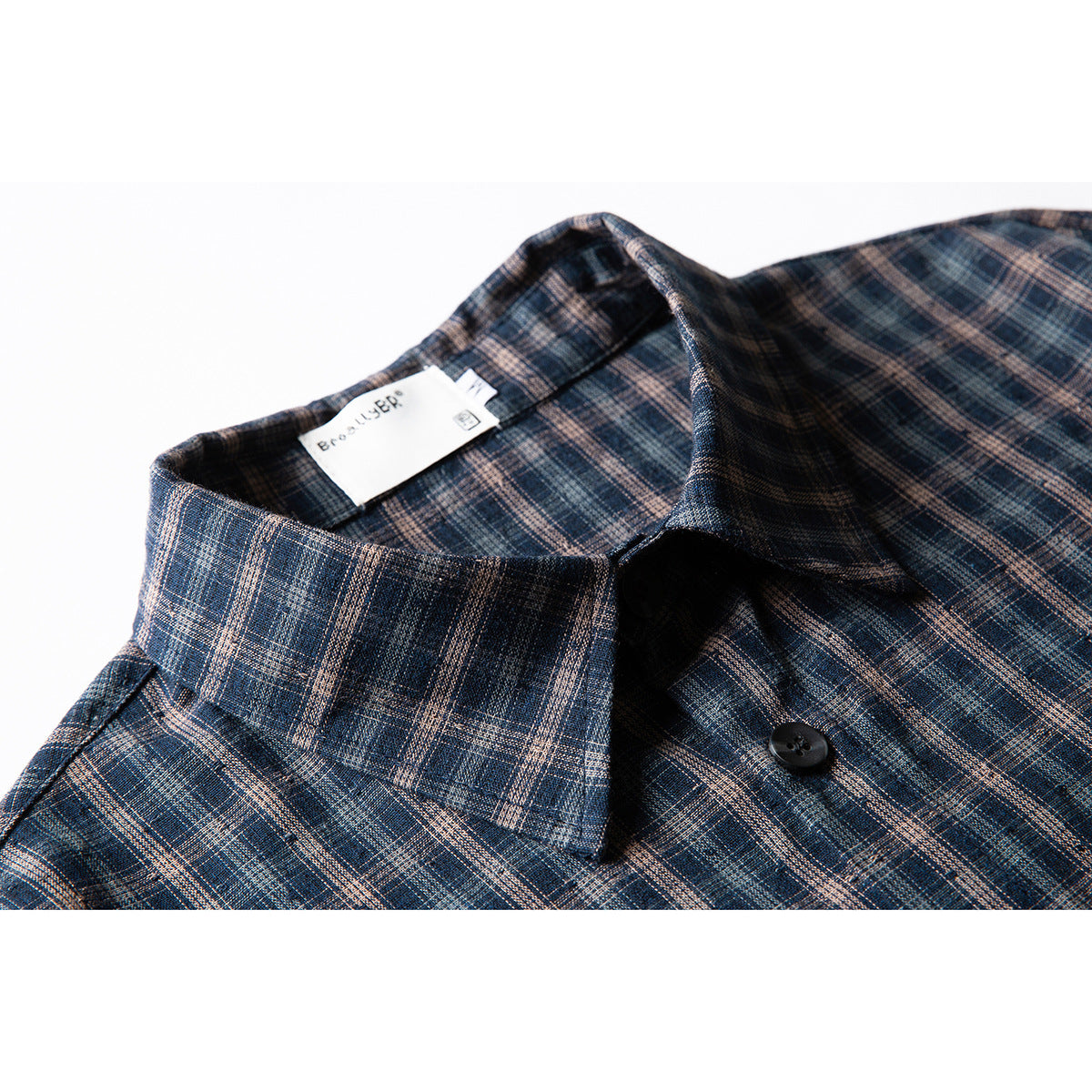 Close-up of a blue and brown plaid shirt collar, button, and sewn-in neck label.
