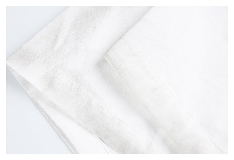 Close-up of white garment fabric with a stitched folded edge.