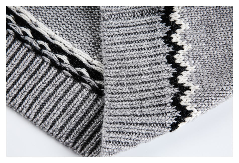 Close-up of the sweater's ribbed hem and knit seam, with gray, black, and cream patterning.