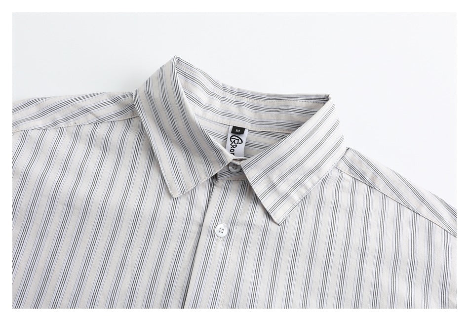Close-up of a white collared shirt with fine gray vertical stripes, showing the collar, button, and neck label.