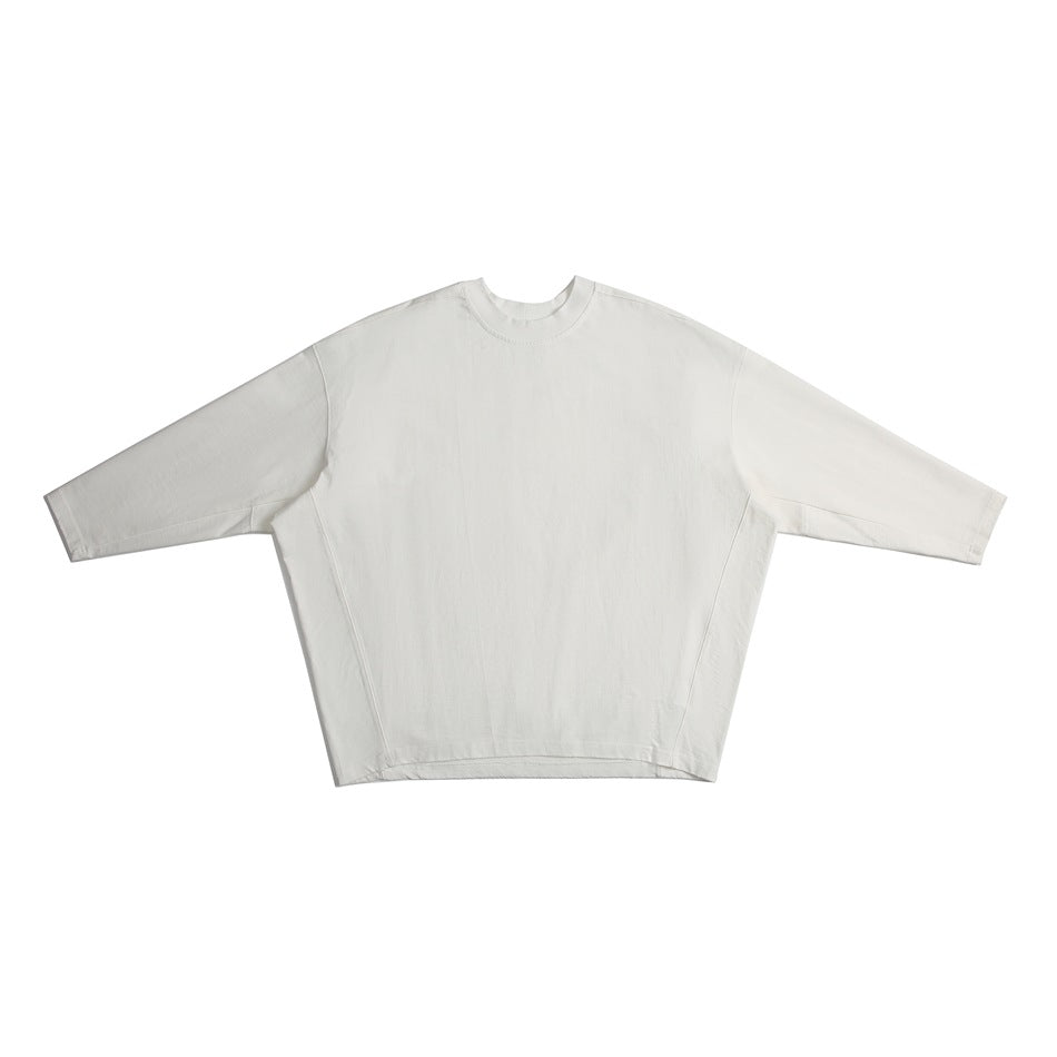 White long-sleeve crew-neck oversized top with batwing sleeves and curved side seams, flat lay front view