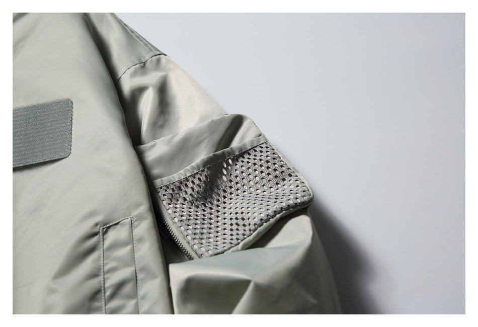 Close-up of the pale gray-green jacket sleeve, showing a wide mesh panel near the cuff.