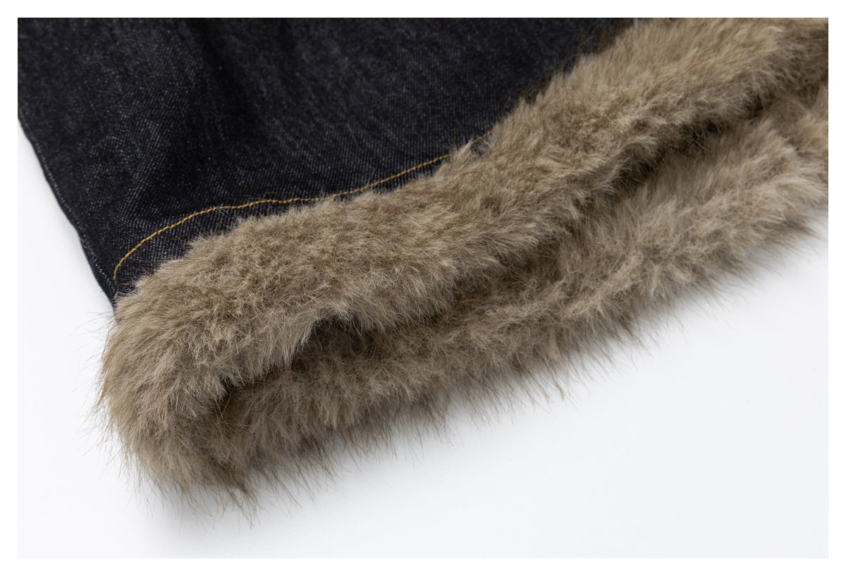 Close-up of taupe faux-fur trim attached to dark denim with golden stitching.
