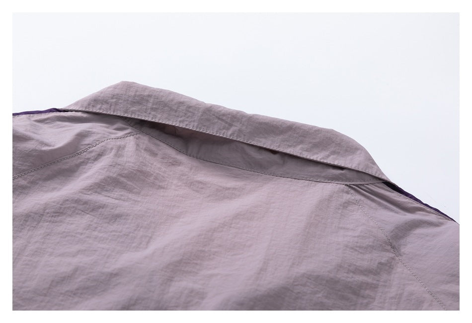 Close-up of a muted mauve-gray garment showing a folded collar or yoke and stitched seams.