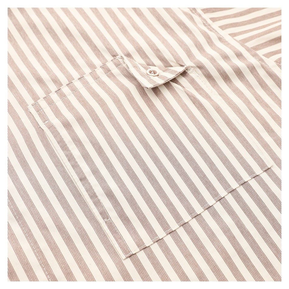 Close-up of a rectangular buttoned pocket on a cream shirt with narrow taupe stripes.