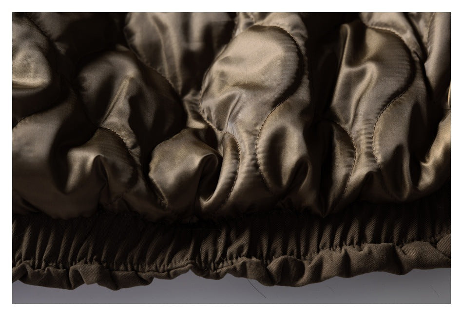 Close-up of the coat's shiny gathered lining and elasticized brown hem.