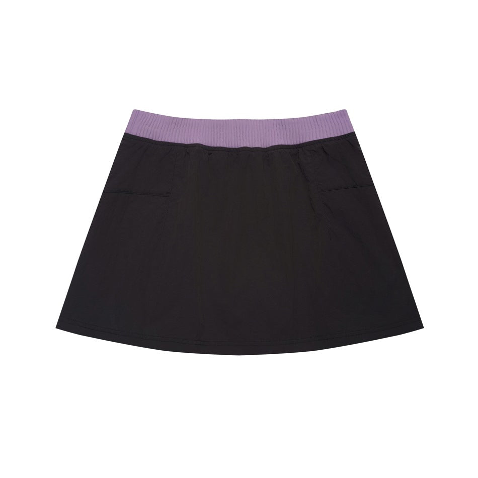 Flat lay of a black flared skirt with a wide lavender ribbed waistband and subtle side pockets.