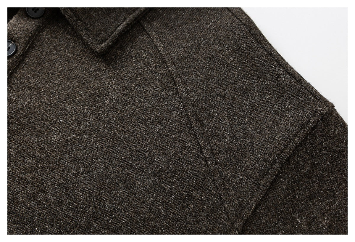 Close-up of a dark brown flecked coat shoulder seam and sleeve.