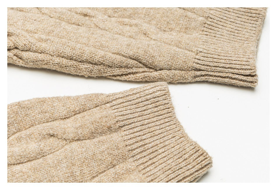 Close-up of beige knit sweater sleeves with wide ribbed cuffs.