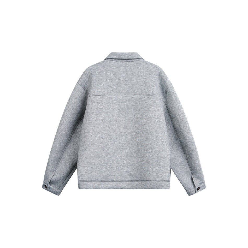 Back view of a light gray jacket with a broad yoke seam, collar, long sleeves, and buttoned cuffs.