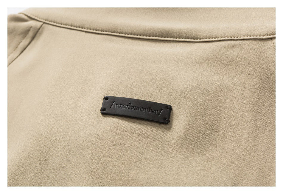Close-up of a beige jacket collar with a small black sewn-on brand label.
