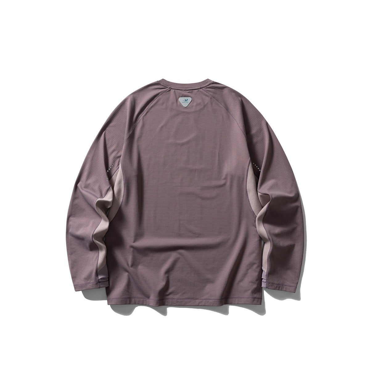 Back view of a muted mauve long-sleeve raglan shirt with a small upper-back patch and reflective sleeve dots.
