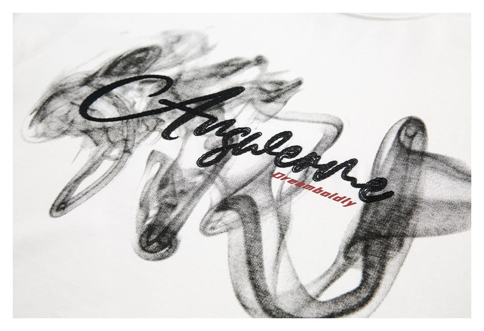 Close-up of a white garment with a black cursive graphic and small red lettering.