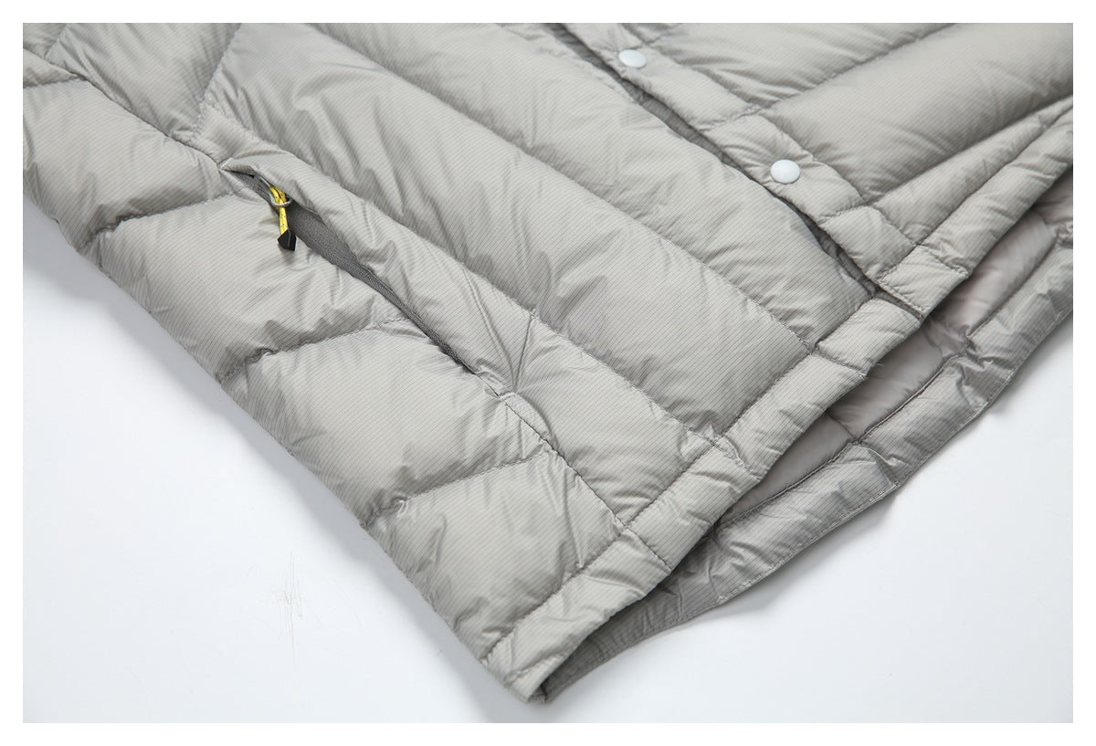 Close-up of a light gray pinstriped quilted jacket with snap closures and a yellow-pull pocket zipper.