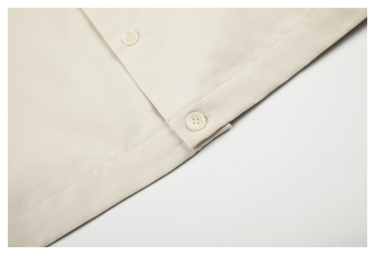 Close-up of an ivory garment cuff with two cream buttons and neat stitching.