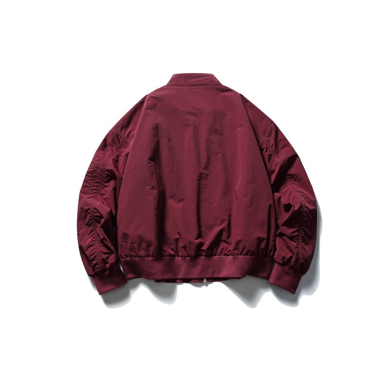 Back view of a burgundy zip jacket with a stand collar, gathered sleeves and ribbed hem and cuffs.