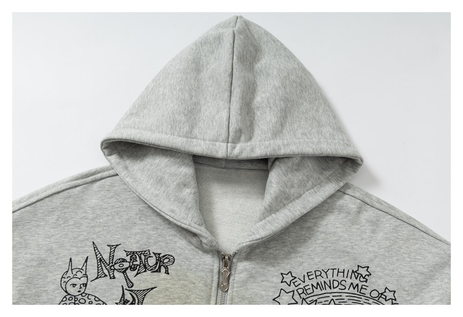 Close-up of the gray hoodie’s hood, zipper, and upper chest with black illustrated print.