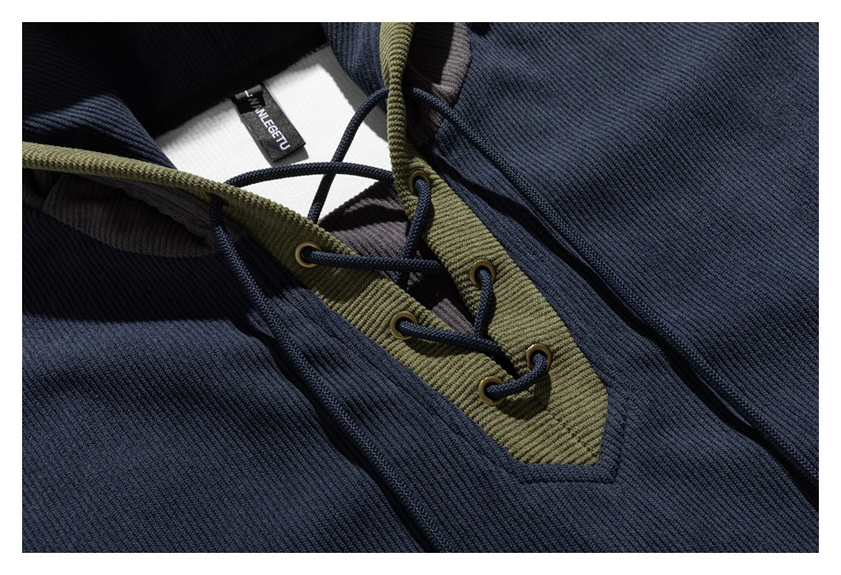 Close-up of navy textured fabric and olive lace-up placket with dark cord and eyelets.