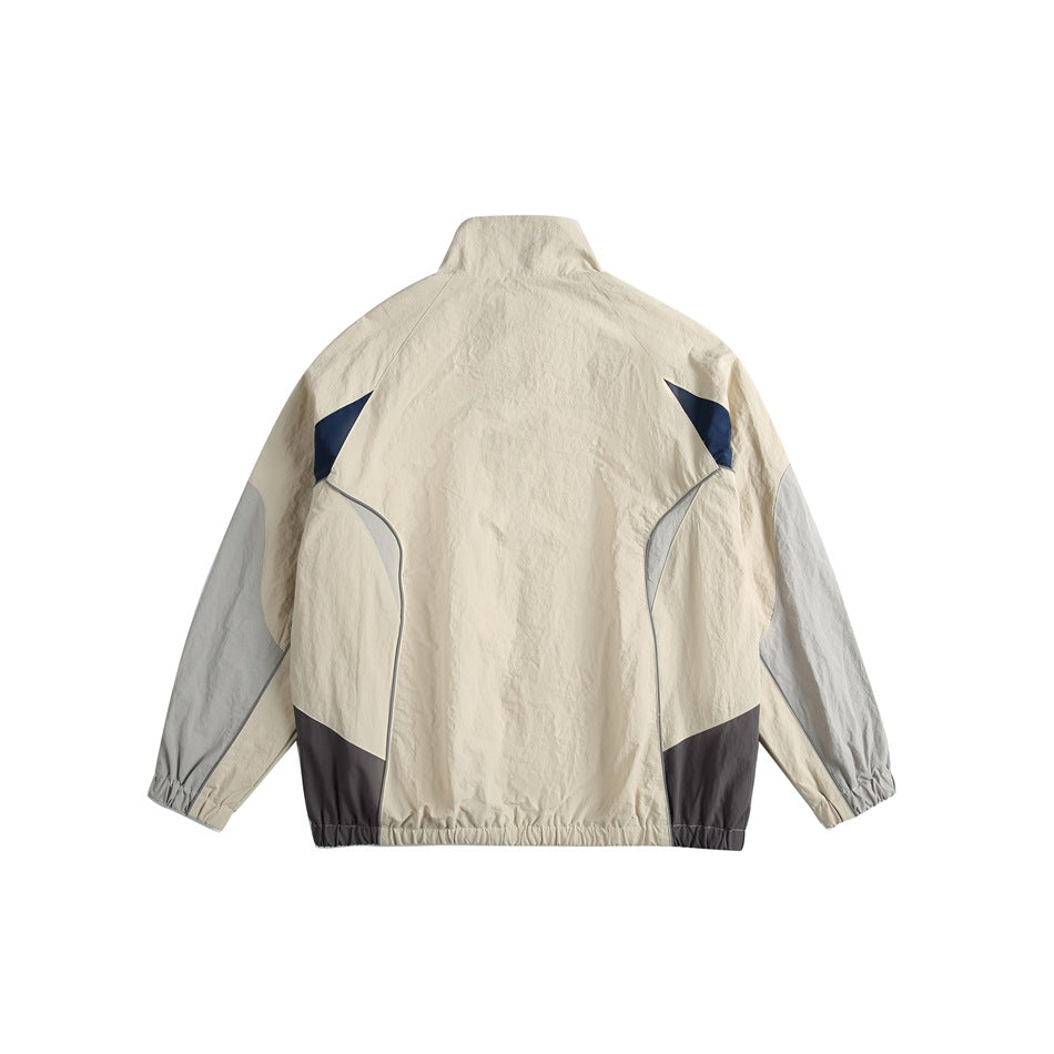 Back view of a cream color-block zip jacket with light gray sleeves, navy accents, and an elasticated hem and cuffs.