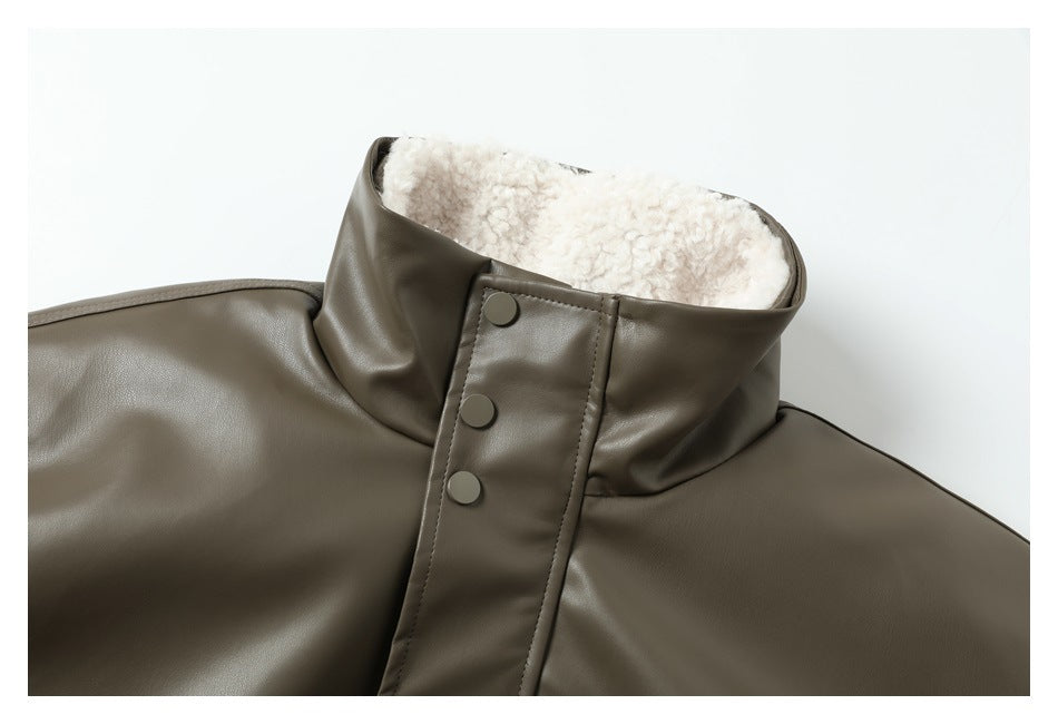 Close-up of the olive-gray jacket's high collar, cream fleece lining, and three snap buttons.