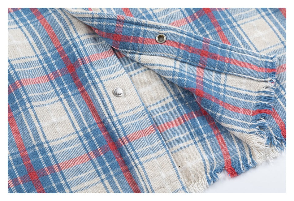 Close-up of the shirt opening, snap fastener, and frayed plaid edge.