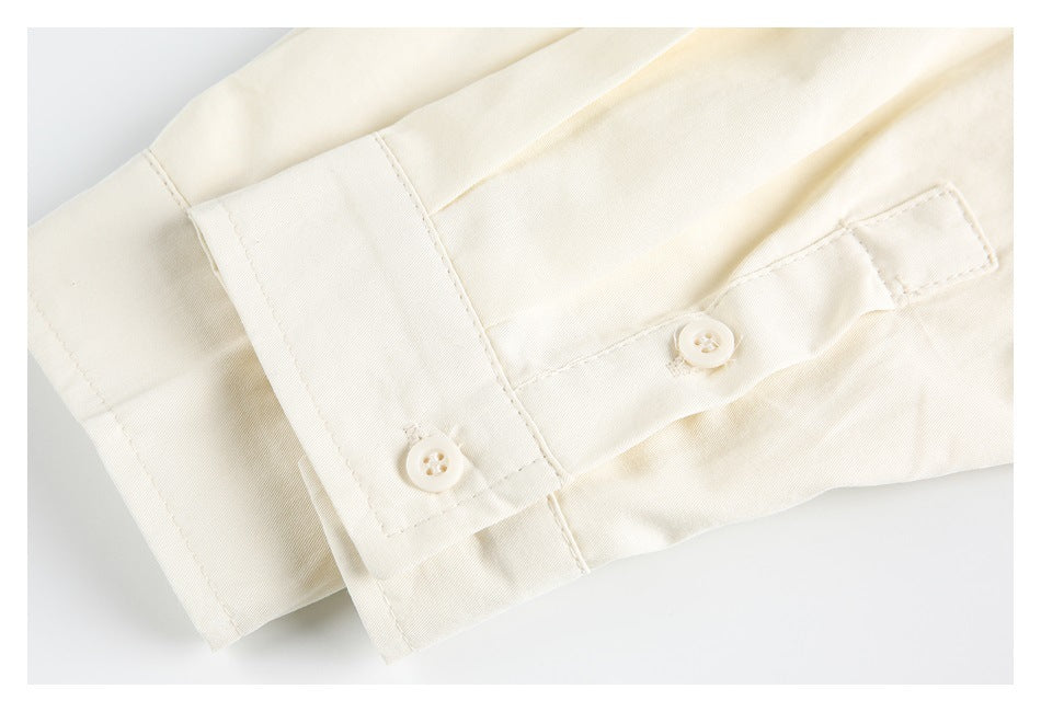 Close-up of an ivory shirt cuff with two buttons and a buttoned sleeve placket.