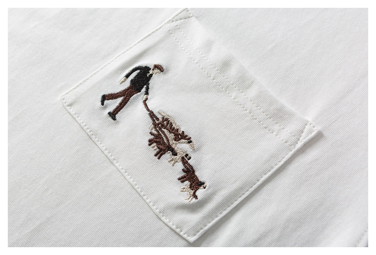 White garment pocket with embroidered artwork of a person walking dogs.