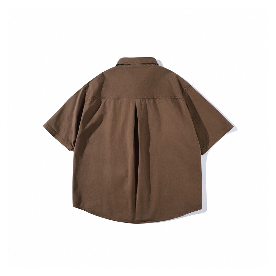 Back view of brown short-sleeve shirt with back yoke, center box pleat and curved hem