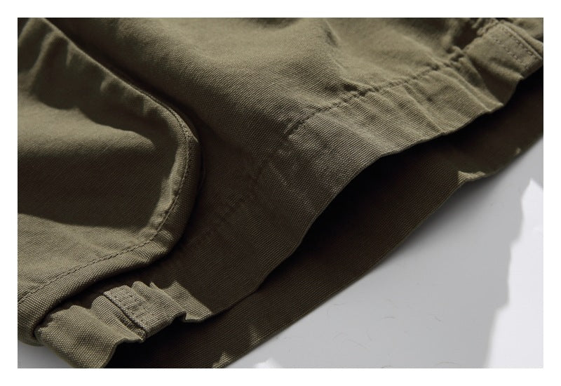 Close-up of olive shorts showing a stitched leg hem and gathered elastic edge.