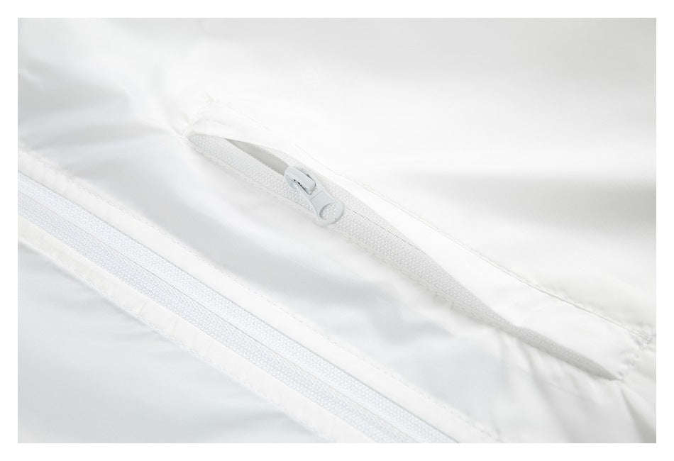 Close-up of a white jacket's zippered pocket beside the main front zipper.