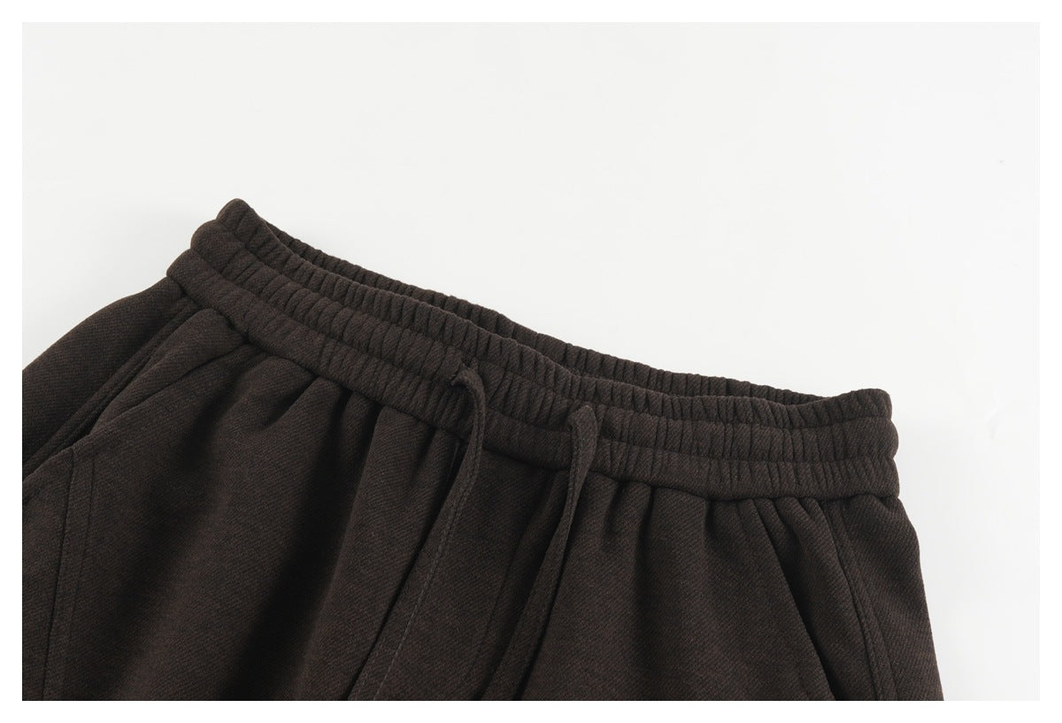 Close-up of dark brown pants showing the gathered elastic waistband and drawstring.