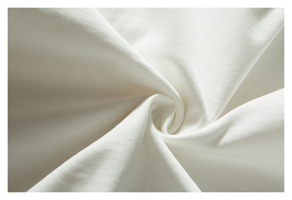 Close-up of off-white T-shirt fabric gathered into a soft spiral fold.