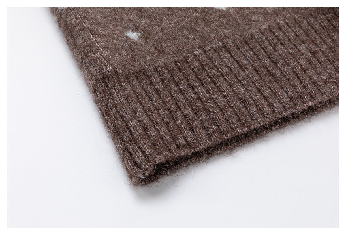 Close-up of the ribbed edge of a brown knit garment with a small pale blue motif.