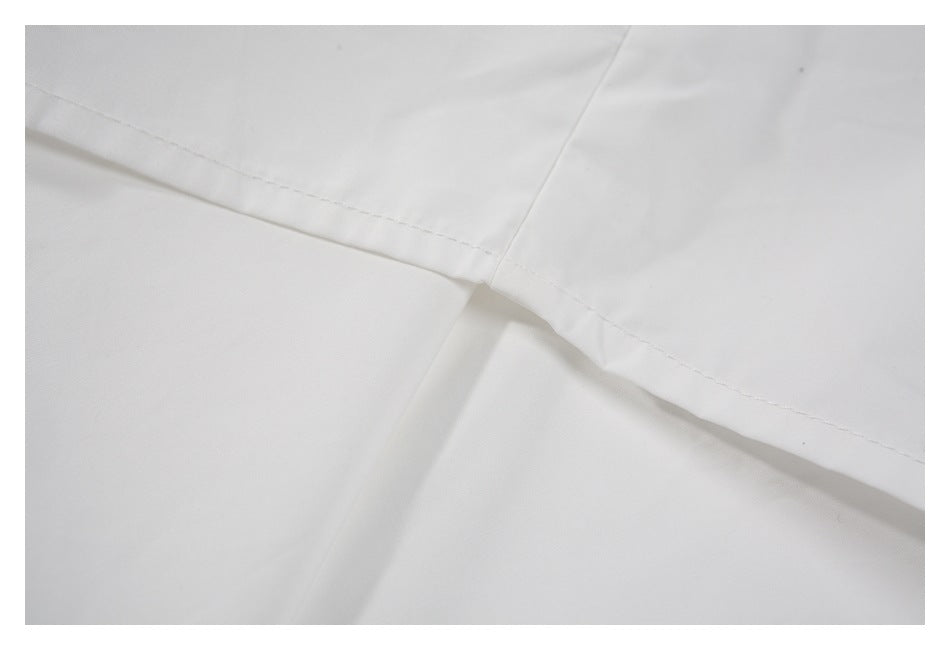 Close-up of white garment fabric with intersecting stitched seams.