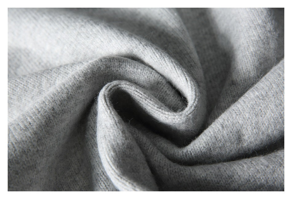 Close-up of light gray knit fabric folded into soft curves.